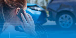 a woman is talking on a cell phone in front of a car accident.