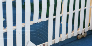 a white picket fence with a hole in it