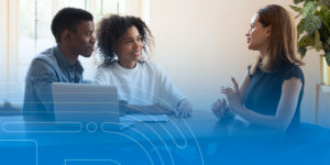 a man and a woman are sitting at a table talking to a woman