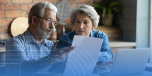 a man and a woman are sitting at a table looking at a piece of paper .