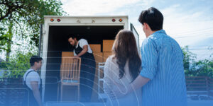 a couple is standing in front of a moving truck .